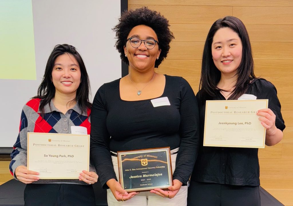 Three students holding their awards