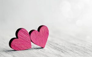 two pink hearts on a white surface